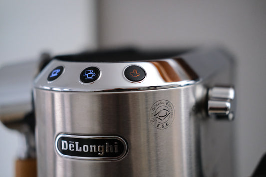 Orange leuchtende Dampftaste an der De'Longhi Dedica EC685 – die Anzeige, dass die Maschine entkalkt werden muss