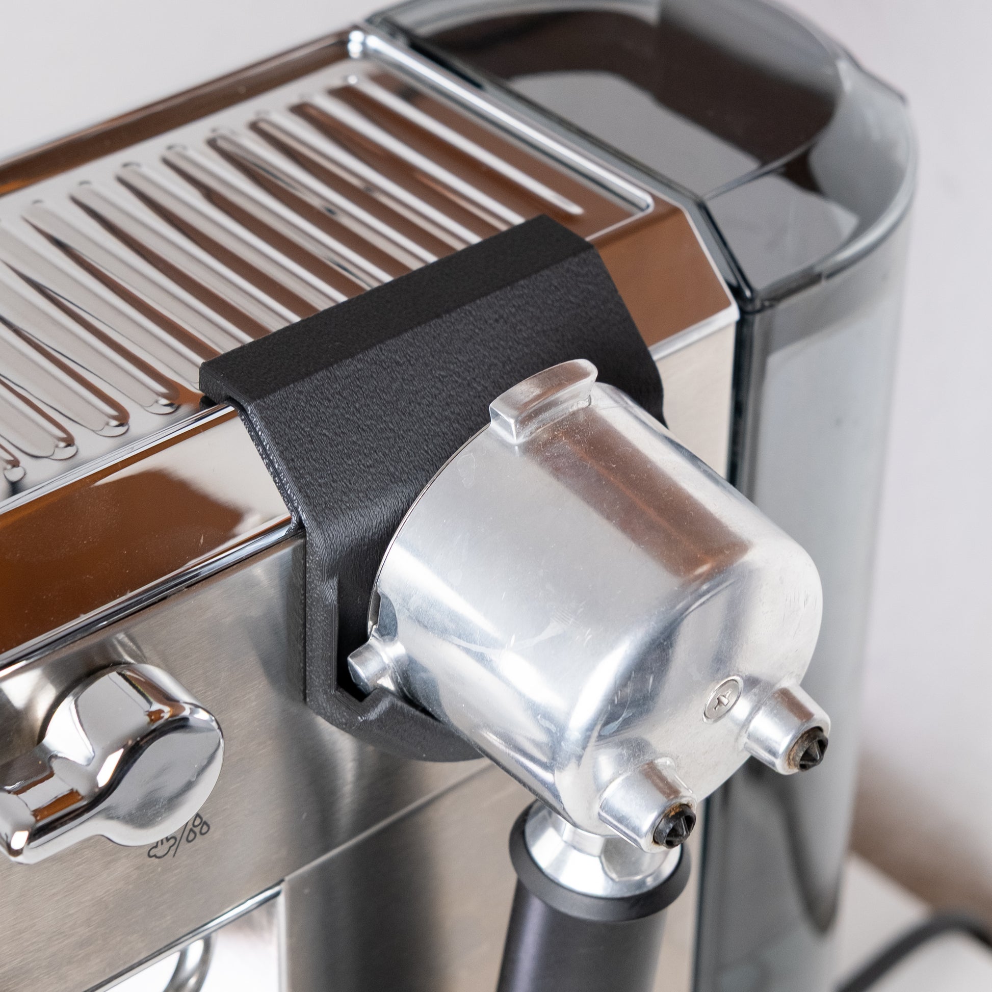 Siebträger mit Siebkorb im magnetischen Halter der De'Longhi Dedica, angewinkelte Ansicht